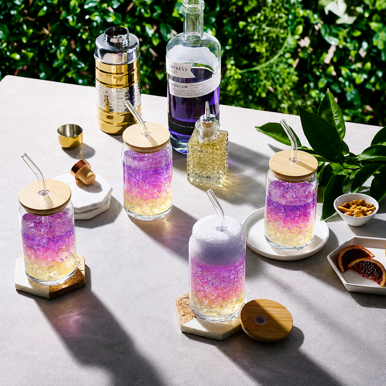 Clear mugs with a colorful purple drink inside with straws on a table outdoors